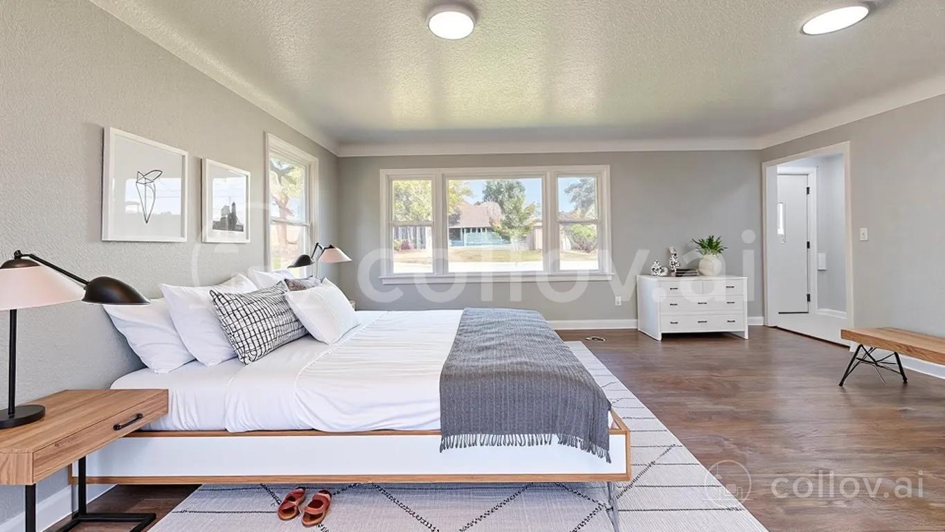 The same room staged as a bedroom by Collov, with a white platform bed, black lamps and a dresser